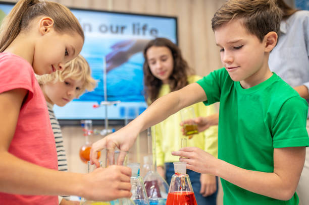 istock Boy and girl sideways to camera doing chemistry experiment 1367212296