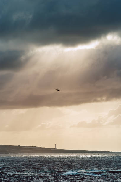 istock the sun's rays beat through the clouds over the rough sea 1367212561