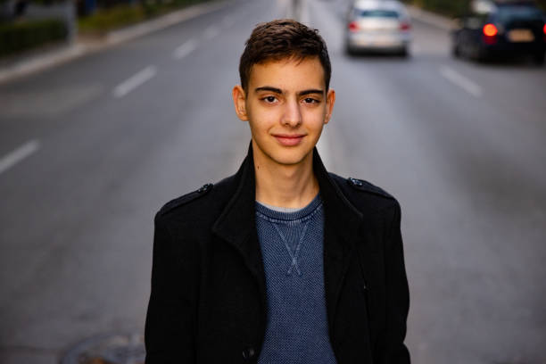 modern 15 year’s old caucasian teenage boy, on the city street - independence lifestyles smiling years imagens e fotografias de stock