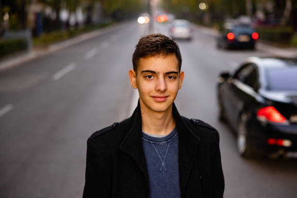 urban 15 year’s old caucasian teenage boy, on the city street - independence lifestyles smiling years imagens e fotografias de stock