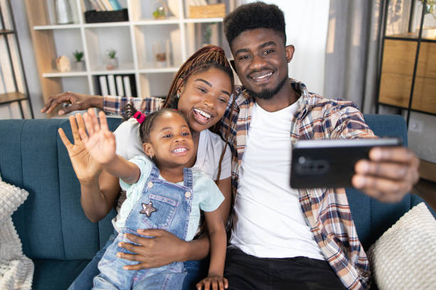 istock African american parents taking selfie with daughter on sofa 1367212994