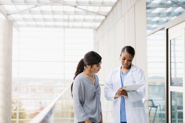 istock Young woman listens as doctor explains test results 1367214024