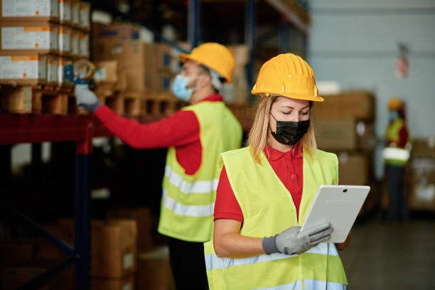 istock Caucasian female worker checking the order inside a warehouse while wearing a face mask - Face focus 1367214106