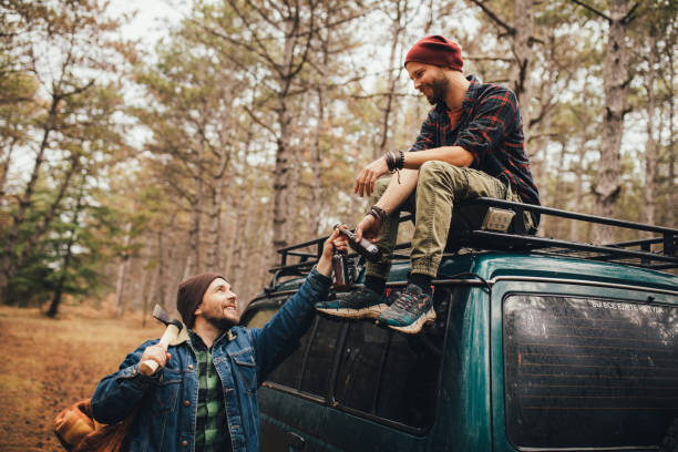 istock Two millennial man hiking in a forest, drinking beer and having fun. 1367215522