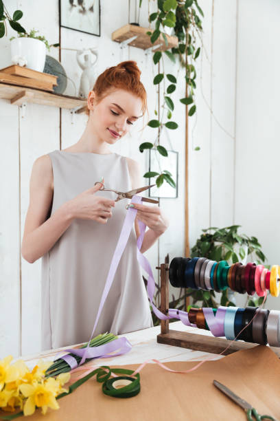 istock Woman using scissors to cut ribbon for bouquet 1367215689