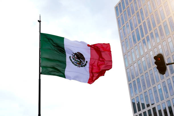 istock Mexican flag waving in the wind over clear sky 1367218427