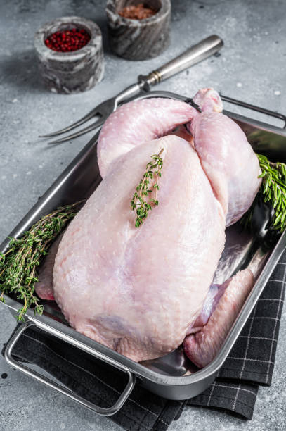 istock Whole raw Free range chicken in kitchen tray with herbs. Gray background. Top view 1367219123