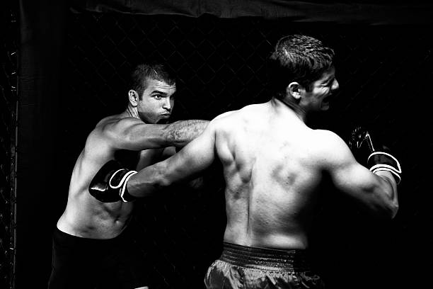 Coach encourages Boxer sitting in the boxing ring corner.