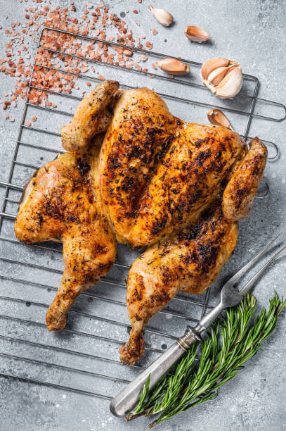 istock Traditional spatchcocked barbecue chicken on grill. Gray background. Top view 1367219906