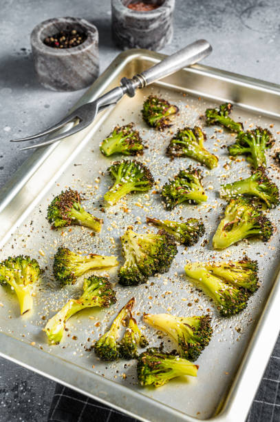 istock Roasted broccoli cabbage with garlic in baking tray. Gray background. Top view 1367222479