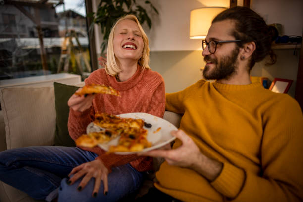 istock Happy couple eating pizza at home 1367222584