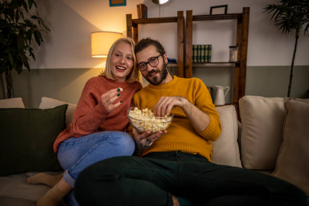 istock Couple watching TV and eating popcorn 1367222710