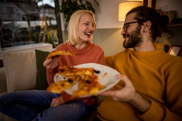istock Happy couple eating pizza at home 1367222867