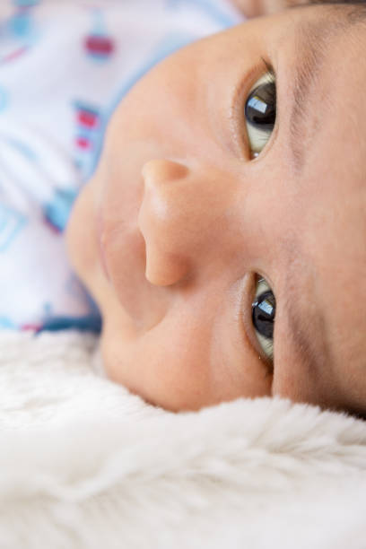 textura do rosto de um bebê latino deitado olhando ao redor, inocência e ternura de um bebê, nova vida e um membro da família - baby boys clothing hospital simplicity - fotografias e filmes do acervo