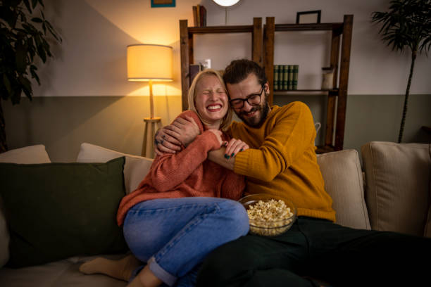 casal assistindo tv e comendo pipoca - family sofa night indoors - fotografias e filmes do acervo