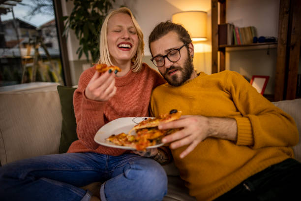 istock Happy couple eating pizza at home 1367224133