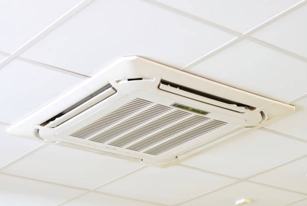 istock cassette type air conditioner mounted on ceiling wall. Air duct on ceiling in farmacy store. Air flow and ventilation system 1367229899