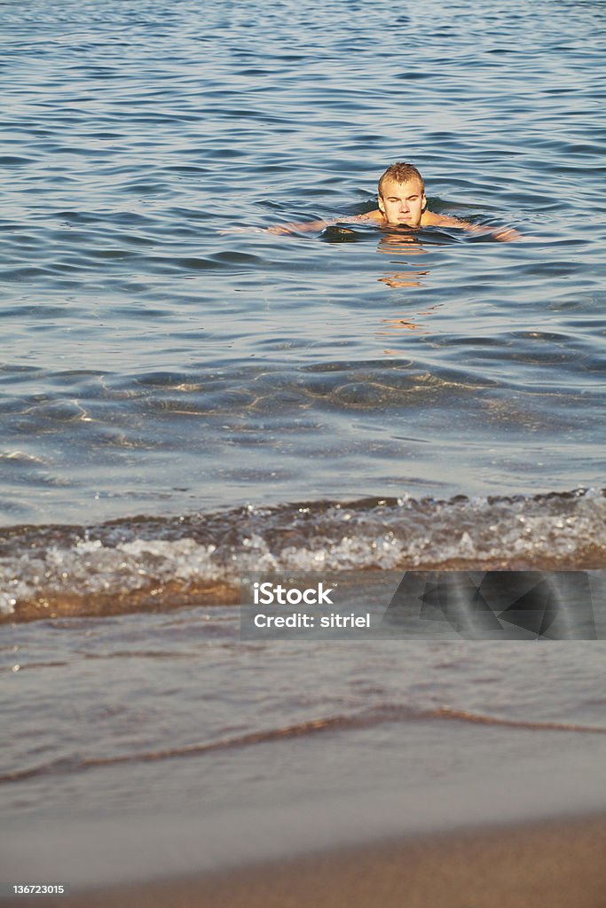 Młody człowiek pływanie w morzu - Zbiór zdjęć royalty-free (Chlapać)