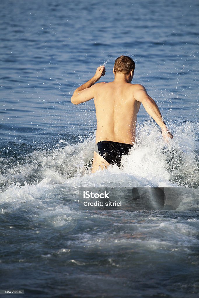 Młody człowiek biegania w wodzie - Zbiór zdjęć royalty-free (Aktywny tryb życia)