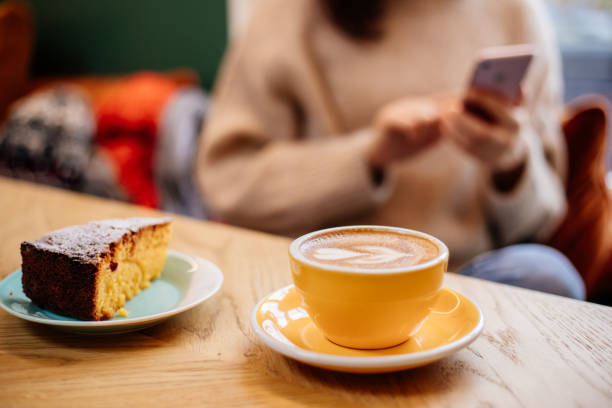 café latte e bolo de laranja na mesa - latté cafe froth art cup - fotografias e filmes do acervo