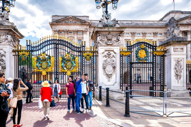 clôture de porte en or au palais de buckingham avec des gens sur la route de rue à londres au royaume-uni - palace buckingham palace london england famous place photos et images de collection