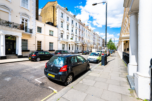 London, UK - June 21, 2018: St George's drive street parking cars parked in Pimlico road by terraced housing balconies buildings and columns in old vintage historic architecture