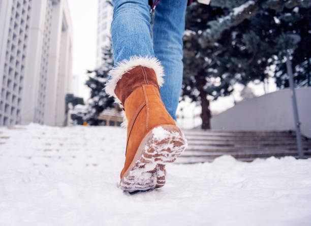 istock Low angle view of women's boots walking on snow 1367236586