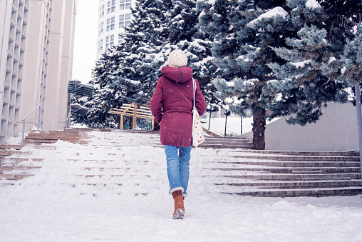 Woman in coat walking by herself in snowy weather, Ankara City