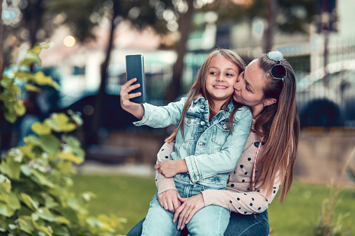 Selfie Time By Smiling Female Child And Kissing Mother