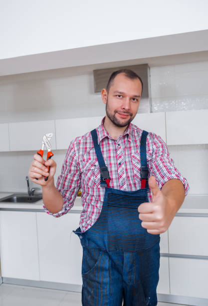 istock Adult guy in uniform with a pliers standing in the kitchen 1367238936