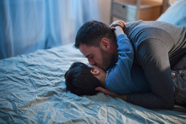 istock Father and son playing and cuddling in bed before bedtime 1367239968