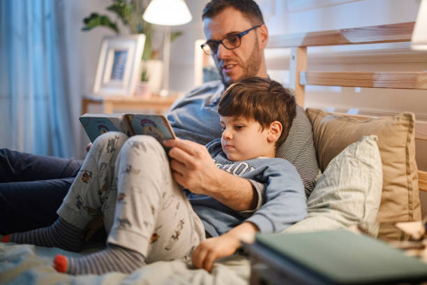 istock Young father reading a bedtime story to his son 1367240207