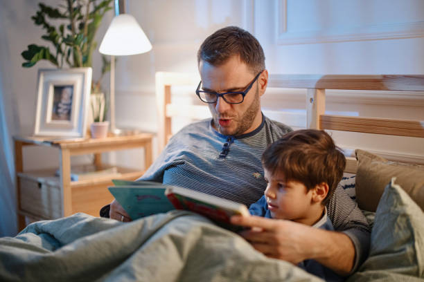 istock Young father reading a bedtime story to his son 1367240377