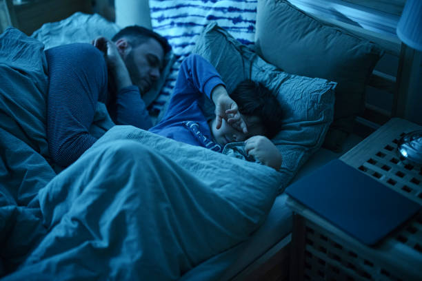 istock Father and son sleeping on the bed 1367240412