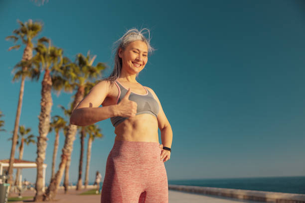 istock Happy pretty woman standing by the waterfront 1367240556