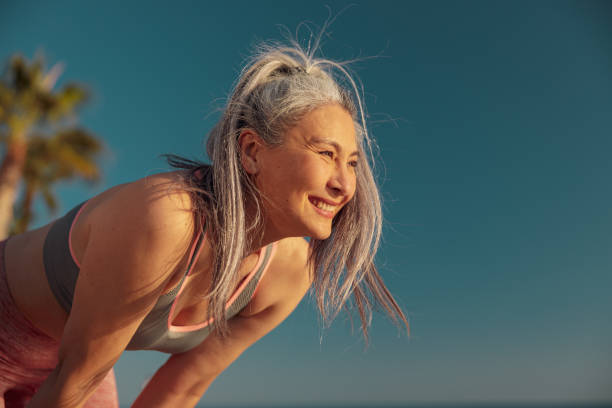 uśmiechnięta ładna kobieta odpoczywająca na ciężkim treningu - breathing exercise jogging exercising relaxation exercise zdjęcia i obrazy z banku zdjęć