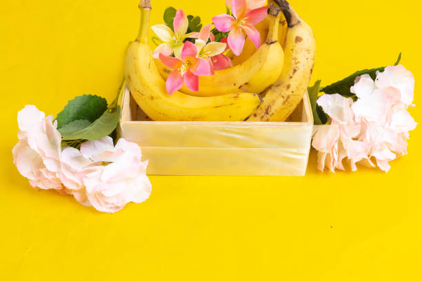 group bananas in wooden box on yellow background