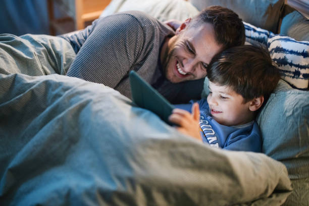 istock Father and son reading bedtime story from digital tablet late at night 1367241248