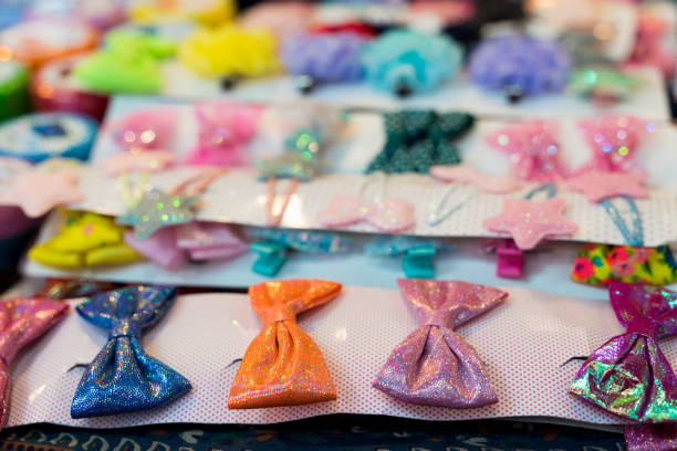 Colorful hair clips close up with bow tie shape at souvenir store. Beauty accessories concept