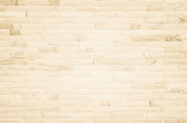istock Empty background of wide cream brick wall texture. Beige old brown brick wall concrete or stone textured, wallpaper limestone abstract flooring/Grid uneven interior rock. Home decor design backdrop. 1367242493