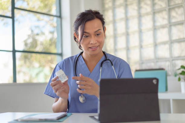Female physician discussing prescription medication with patient during virtual appointment stock photo