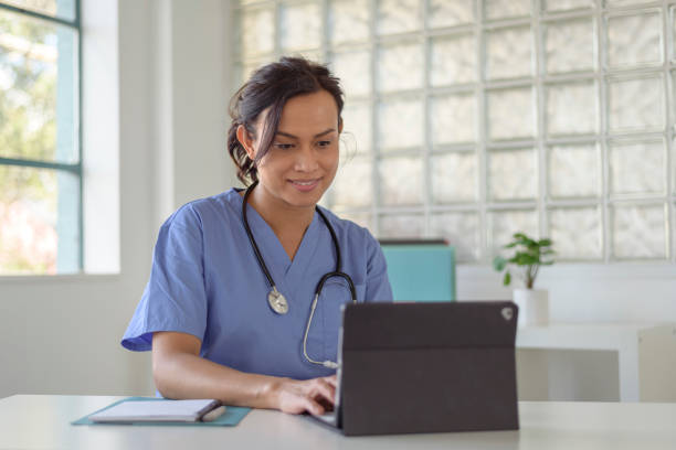istock Female doctor reviews patient records on tablet computer 1367243479