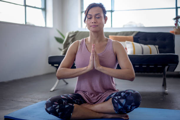 istock Woman meditating at home 1367243525