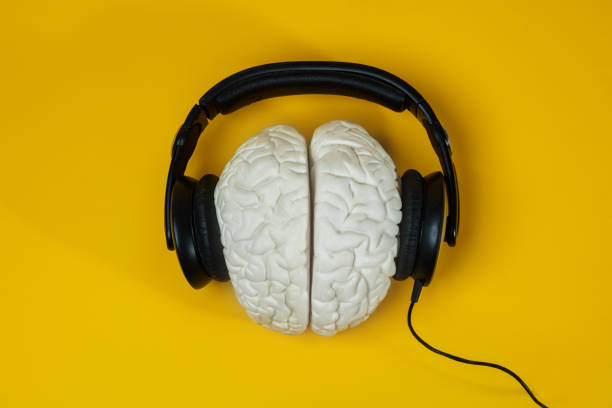 fones de ouvido no cérebro sobre fundo amarelo - creative thinking audio - fotografias e filmes do acervo