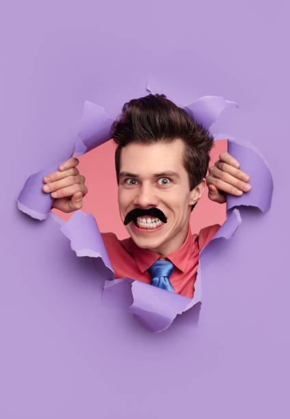 istock Funny detective tearing hole in paper 1367247161