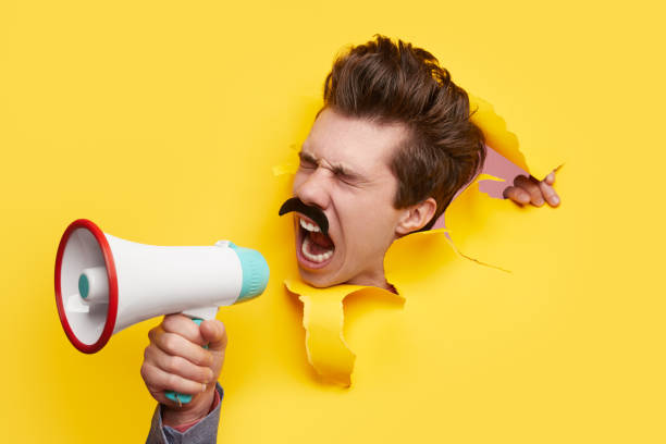 istock Funny man screaming in loudspeaker 1367247164