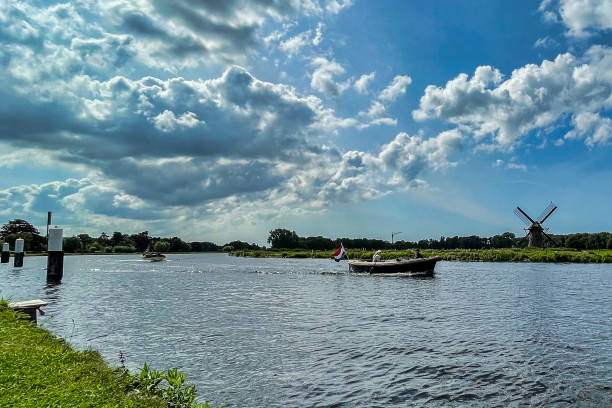 Leidschendam, Netherlands - 24 August 2021: people are sitting on a small boat on a dutch river and cloud formation