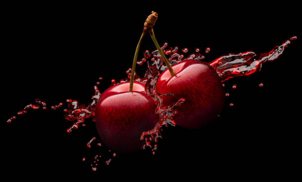 rote kirschen in rotem saft spritzen auf schwarzem grund - black cherries stock-fotos und bilder