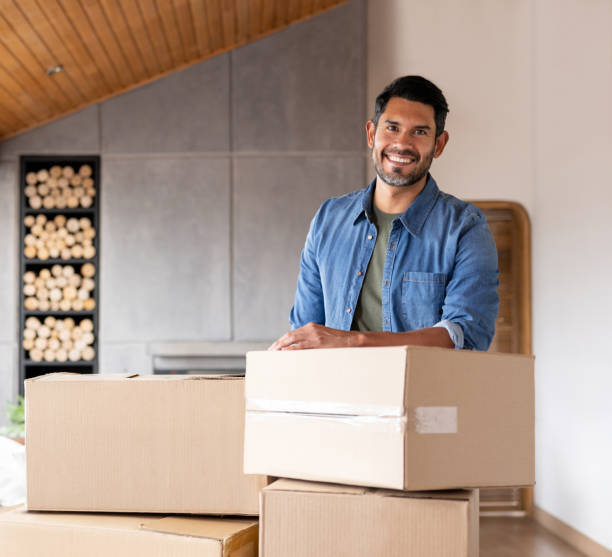 istock Happy man moving house and packing boxes 1367252545
