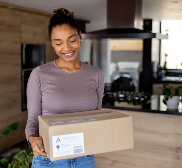 istock Happy woman receiving a package at home 1367252571